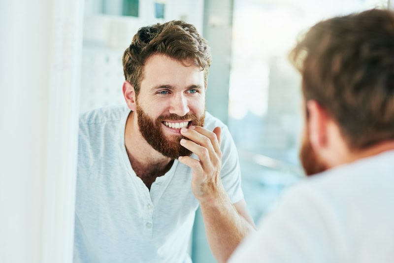 Man looking at his teeth in mirror