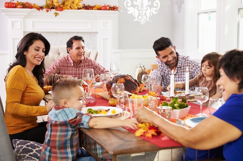 Family eating Thanksgiving dinner, smiling with beautiful, healthy, white teeth