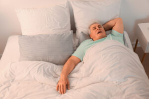 A man with sleep apnea lying on his back in bed