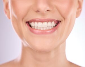 Young woman smiles brightly, showing off her new porcelain veneers